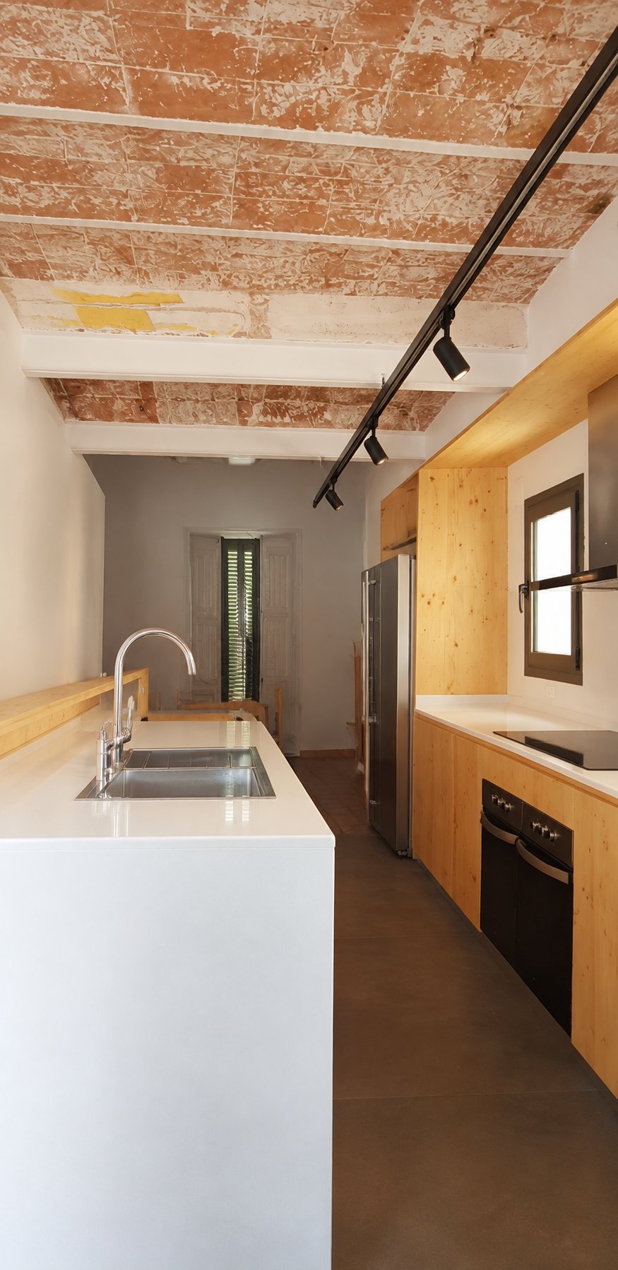 Cocina compartida reformada en una residencia de estudiantes, con techo de bóveda catalana