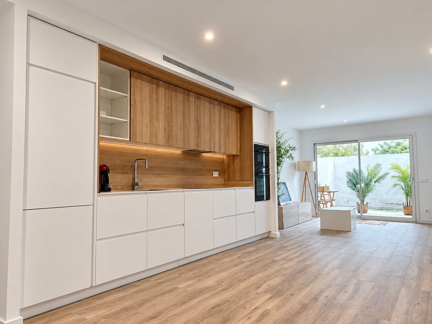 Cocina abierta al salón con salida a un patio en un local convertido en vivienda